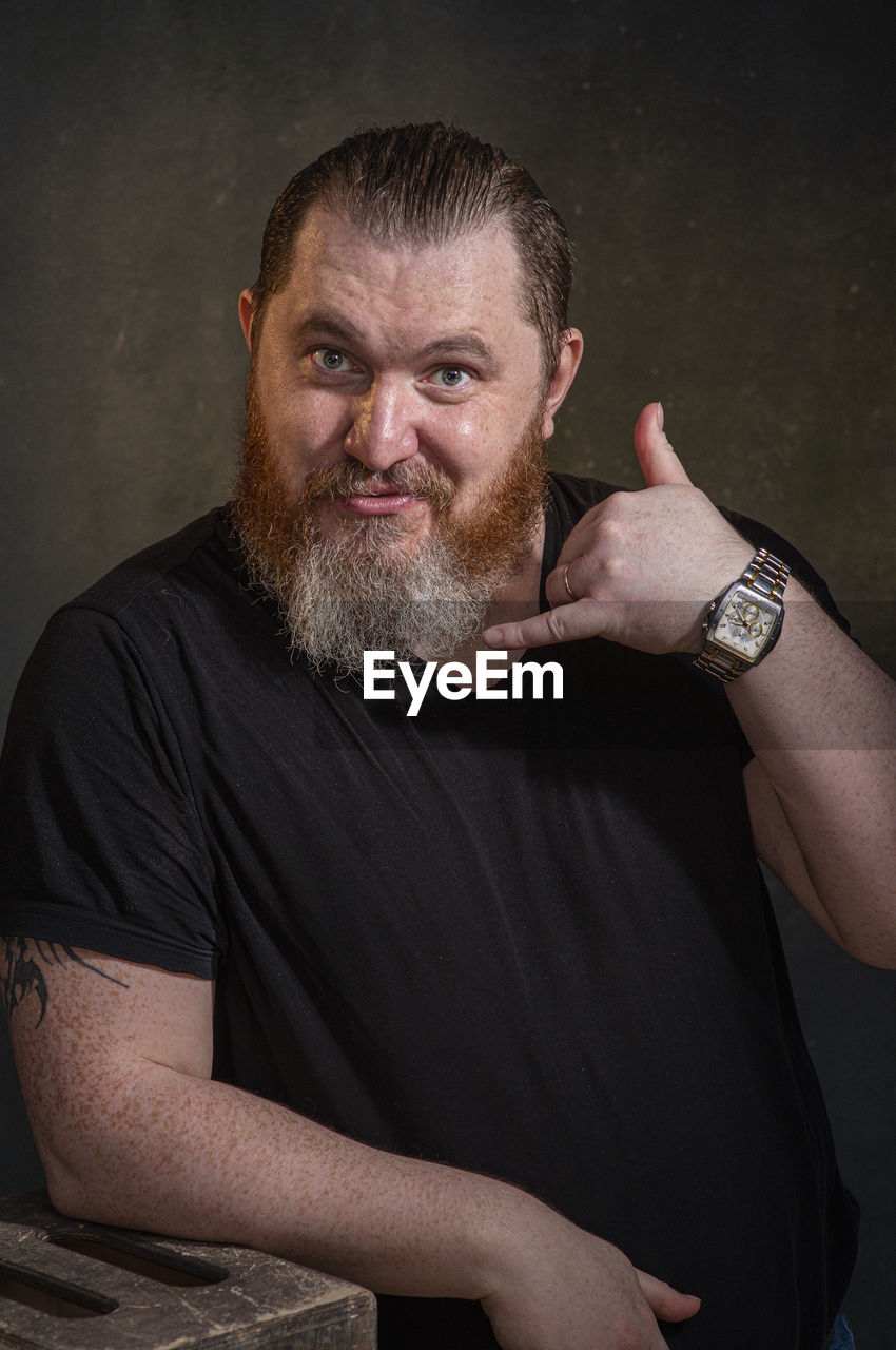 facial hair, one person, adult, men, beard, portrait, watch, person, looking at camera, human hair, indoors, studio shot, waist up, emotion, mature adult, hairstyle, hand, arm, front view, human face, lifestyles, tattoo, black, individuality, casual clothing, jewelry