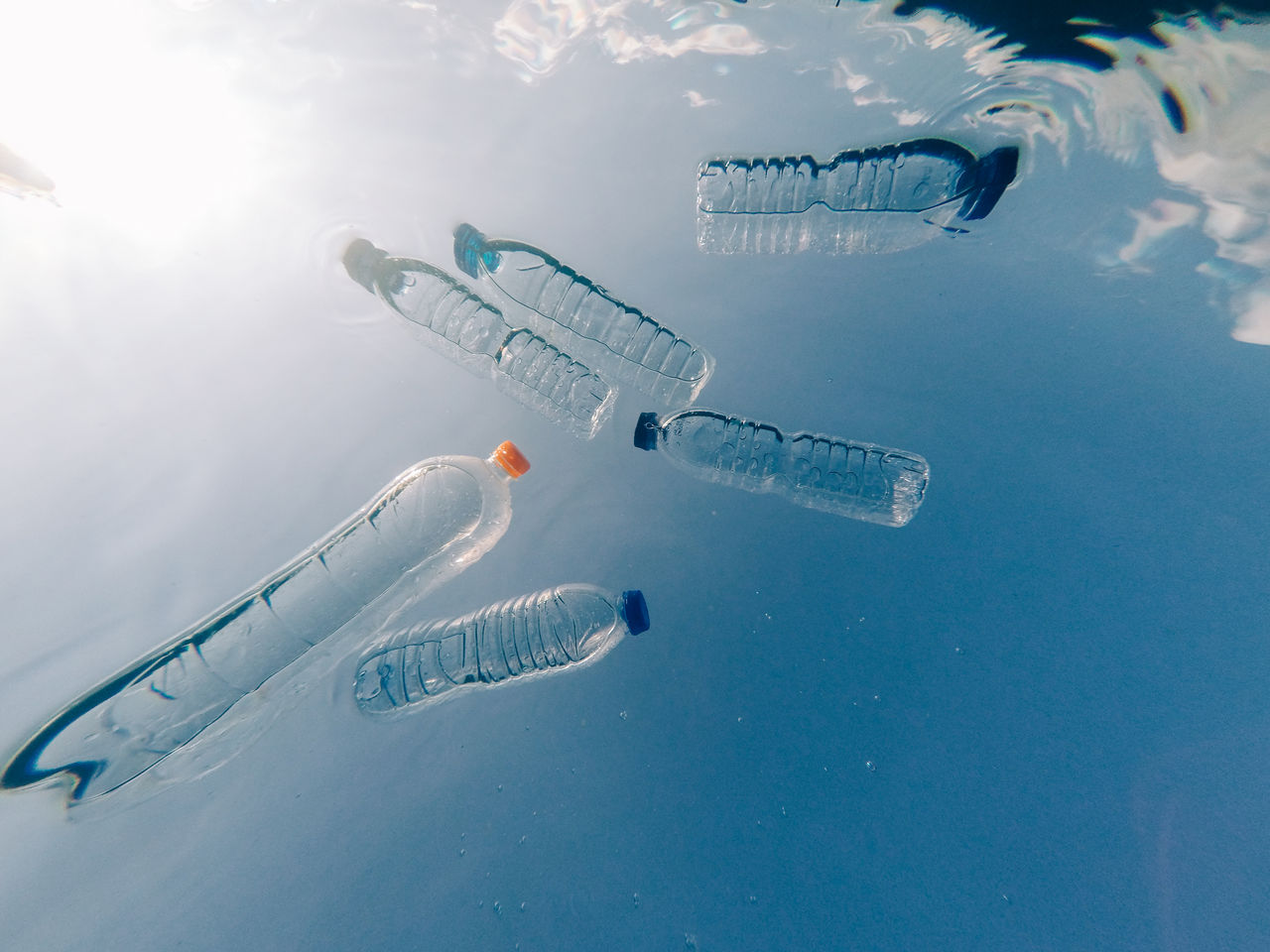 High angle view of water bottles floating on sea