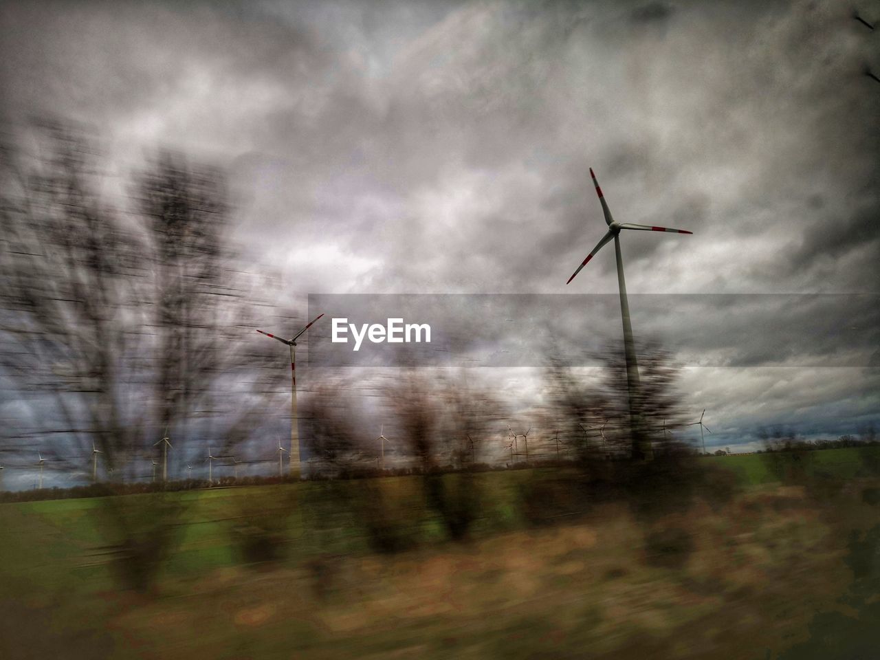 LOW ANGLE VIEW OF WIND TURBINE ON FIELD AGAINST SKY