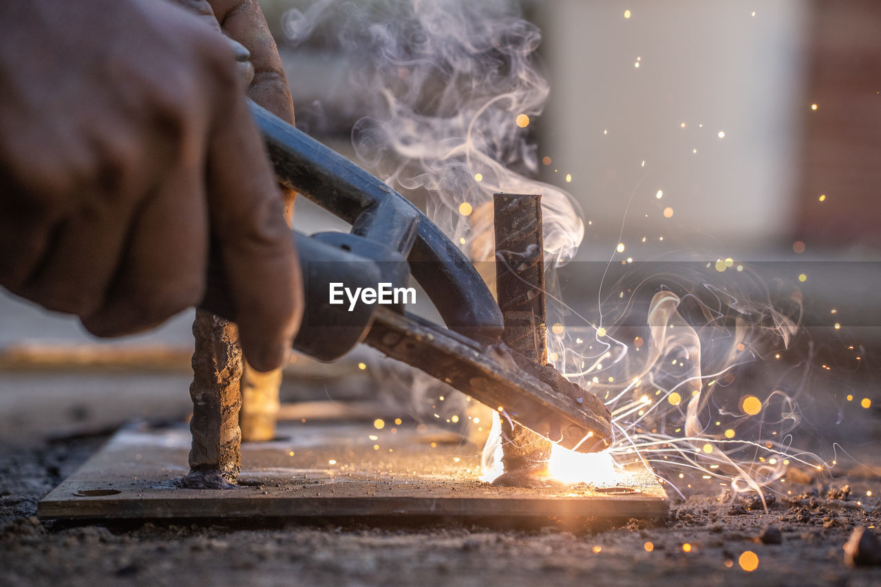 Cropped hands of worker welding metal in workshop