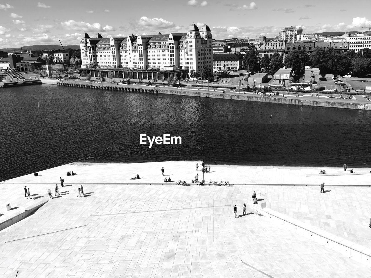 People walking at oslo opera house against city skyline