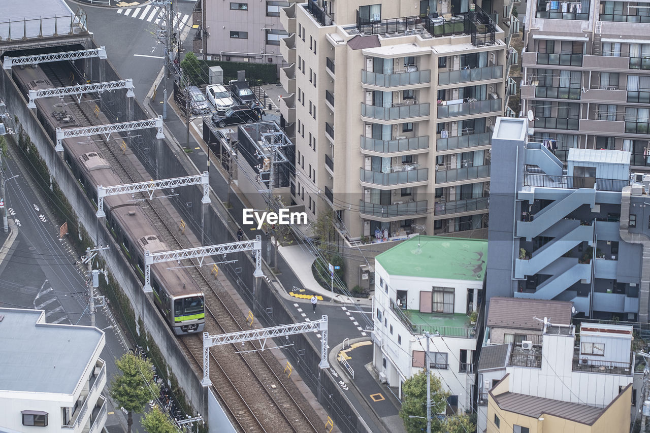 HIGH ANGLE VIEW OF STREET AMIDST BUILDINGS