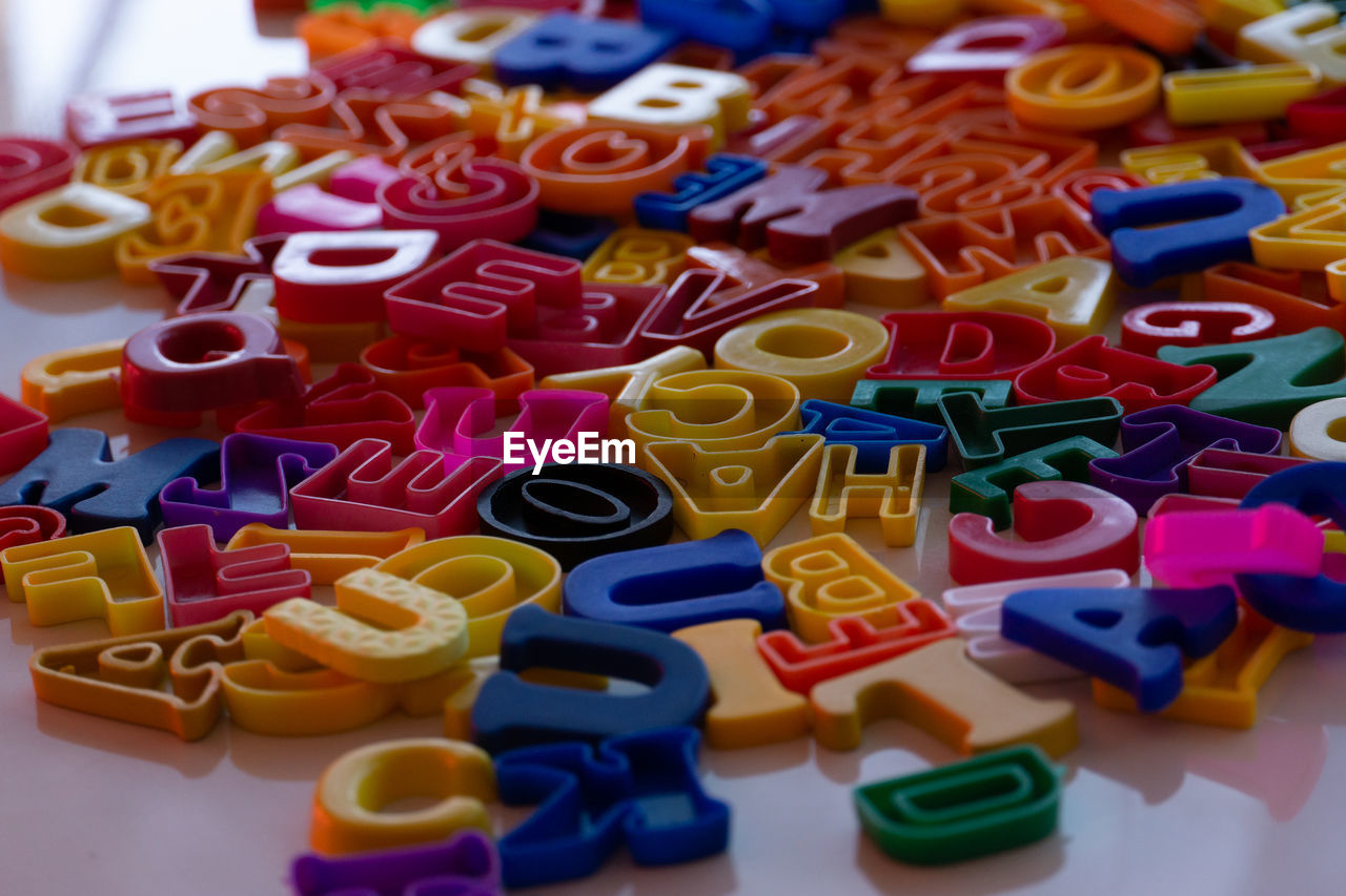 multi colored, large group of objects, indoors, toy, no people, variation, abundance, still life, close-up, letter, high angle view, alphabet, text, toy block, dessert