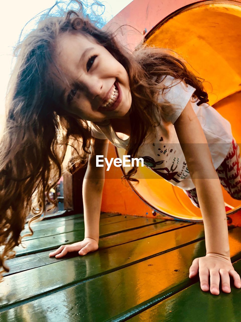 Portrait of happy girl playing on slide