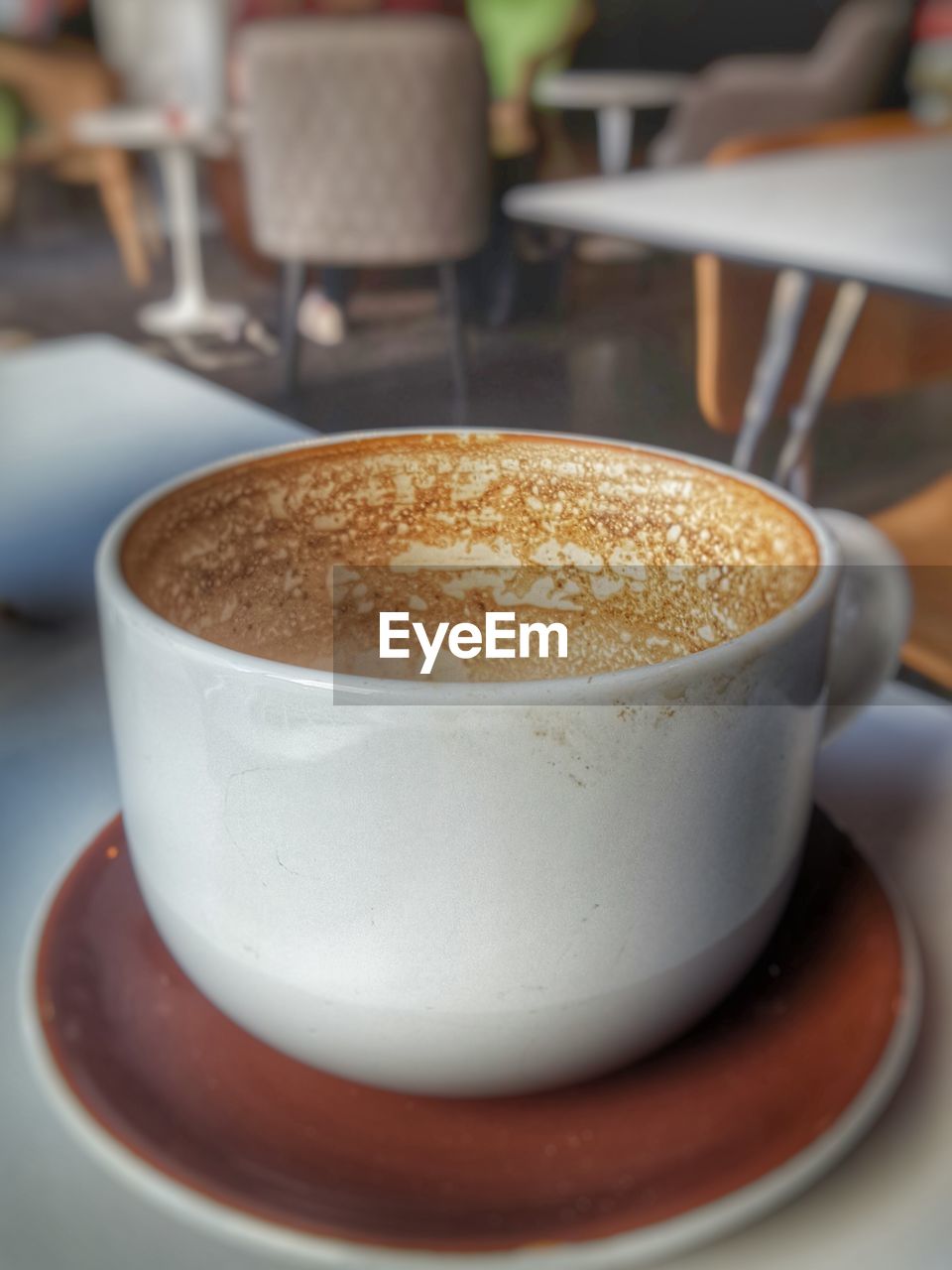 CLOSE-UP OF COFFEE CUP WITH COFFEE CUP ON TABLE