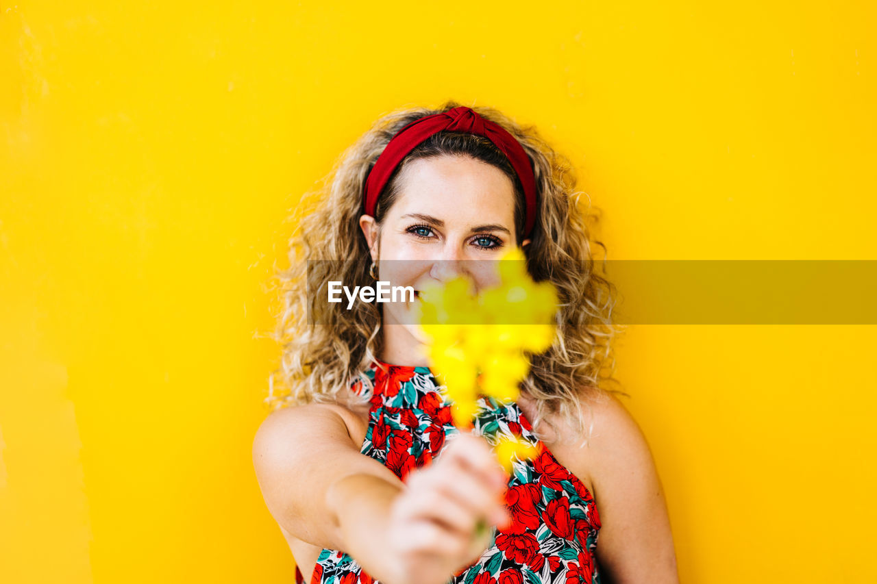 Portrait of smiling beautiful girl on yellow background