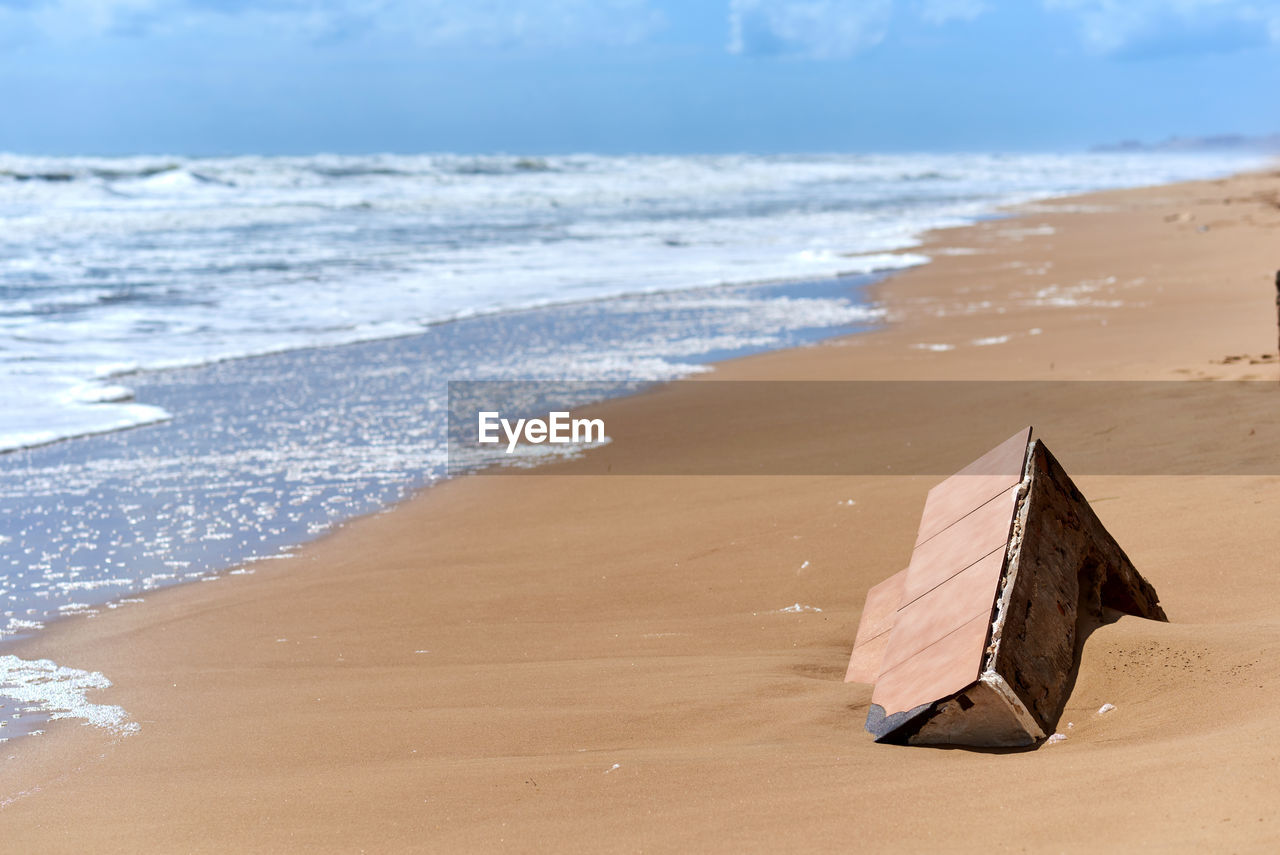 Box in sand on shore at beach