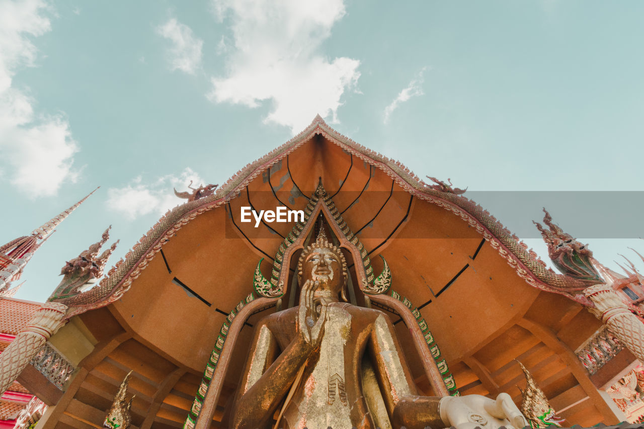 Low angle view of statues on building against sky