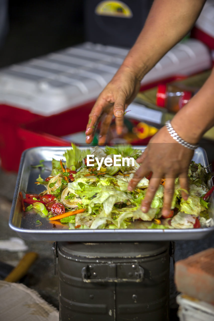 Man tossing salad in tray