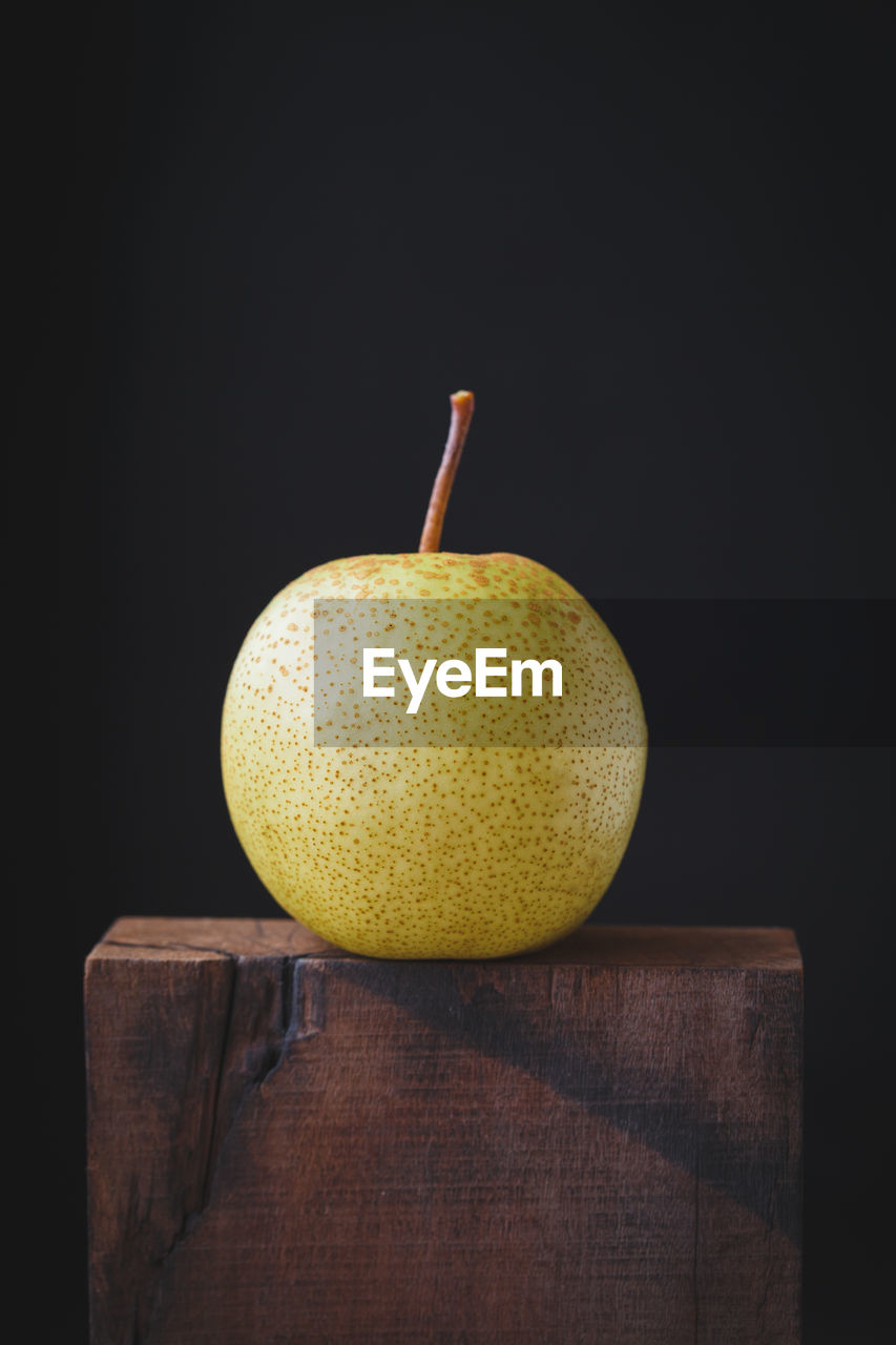 Close-up of granny smith apple on table against black background
