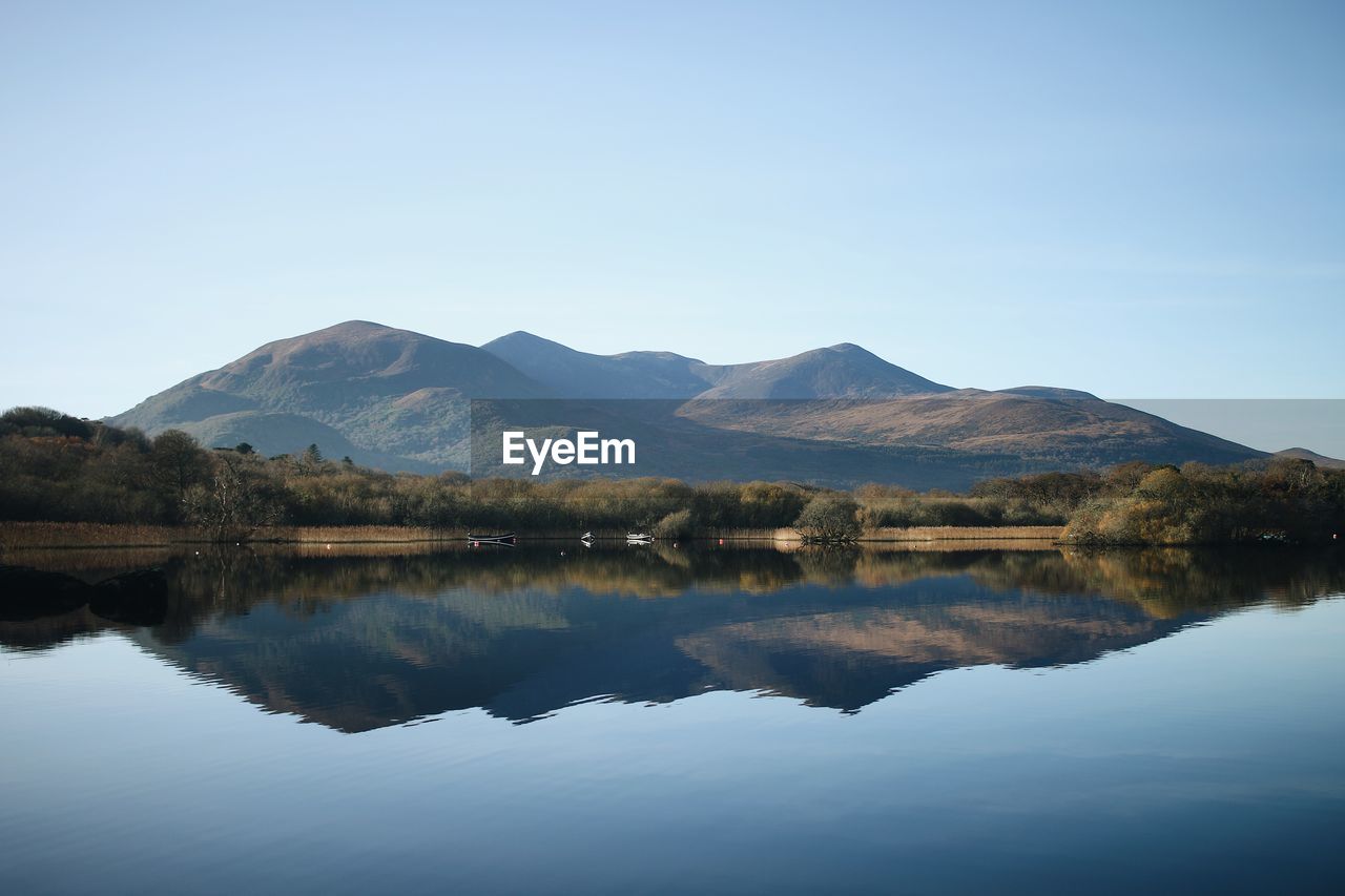 Scenic view of lake and mountains against clear sky