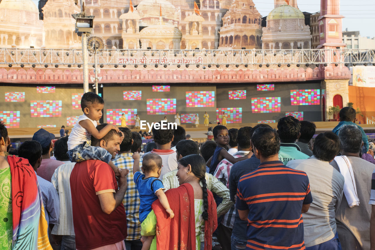 REAR VIEW OF PEOPLE STANDING AT TEMPLE