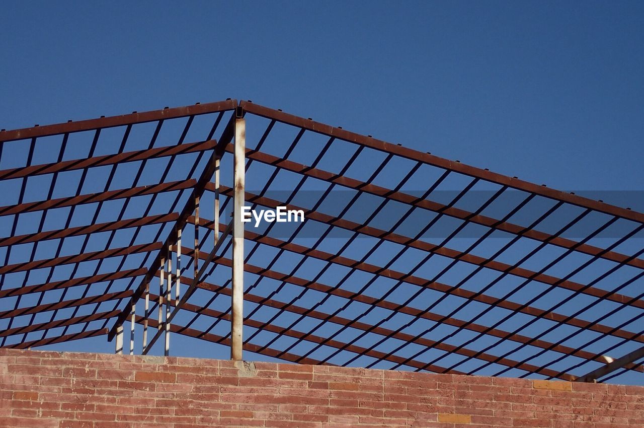 Low angle view of metallic roof frame against clear sky