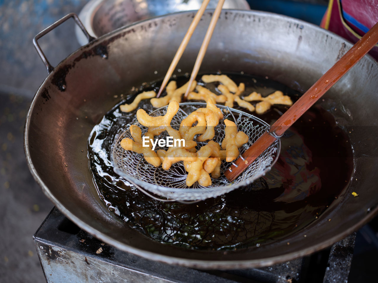 Die cut of deep fried chinese doughnut in an big oil pan