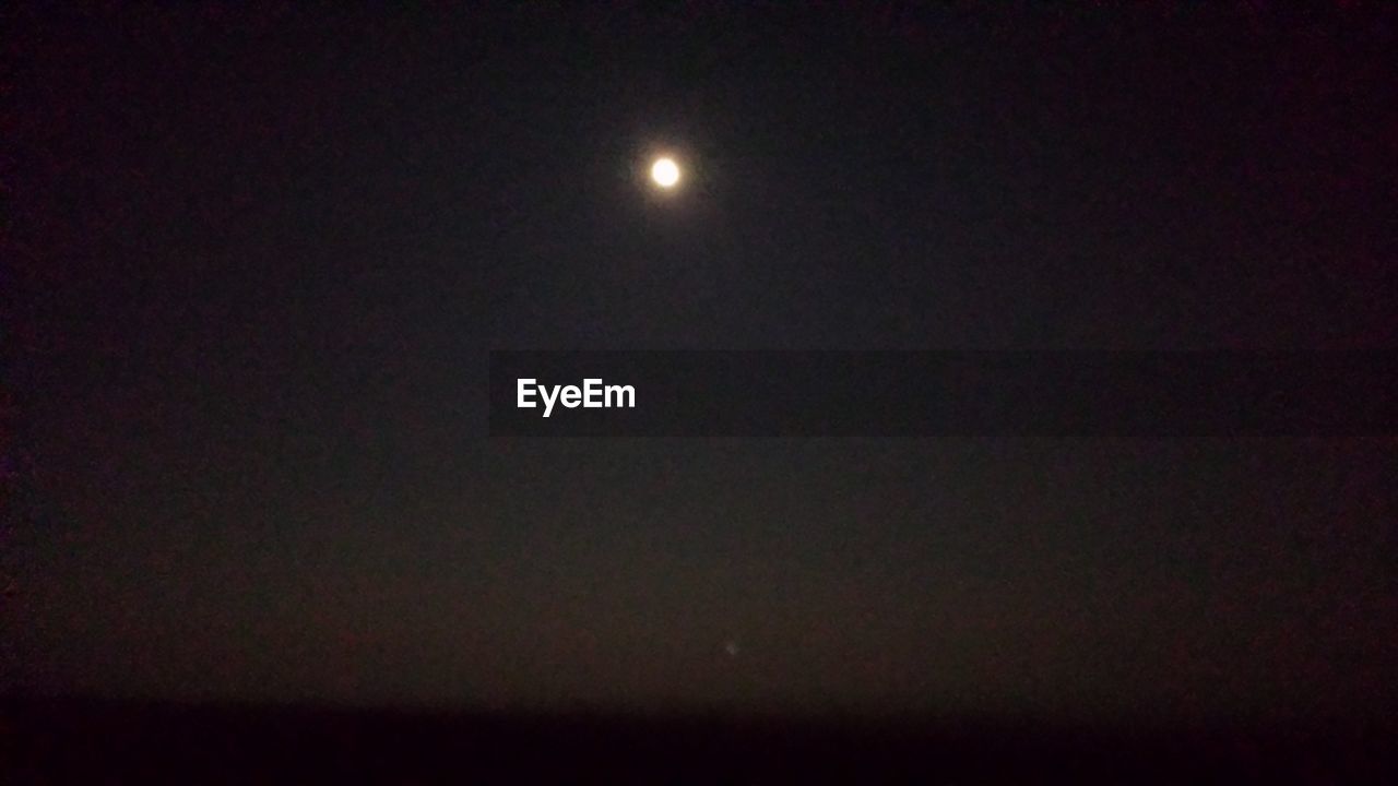 LOW ANGLE VIEW OF MOON IN SKY