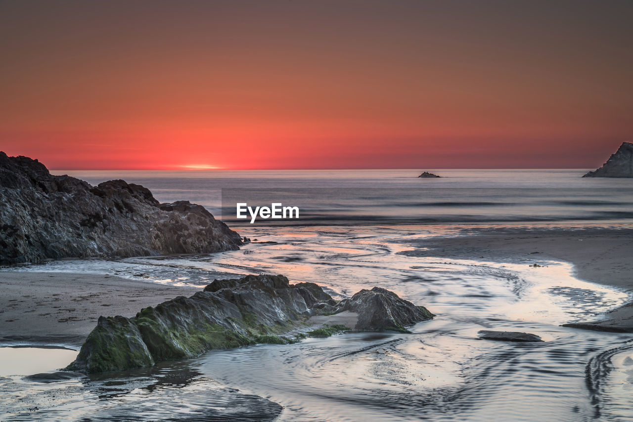 SCENIC VIEW OF SEA AGAINST SUNSET SKY