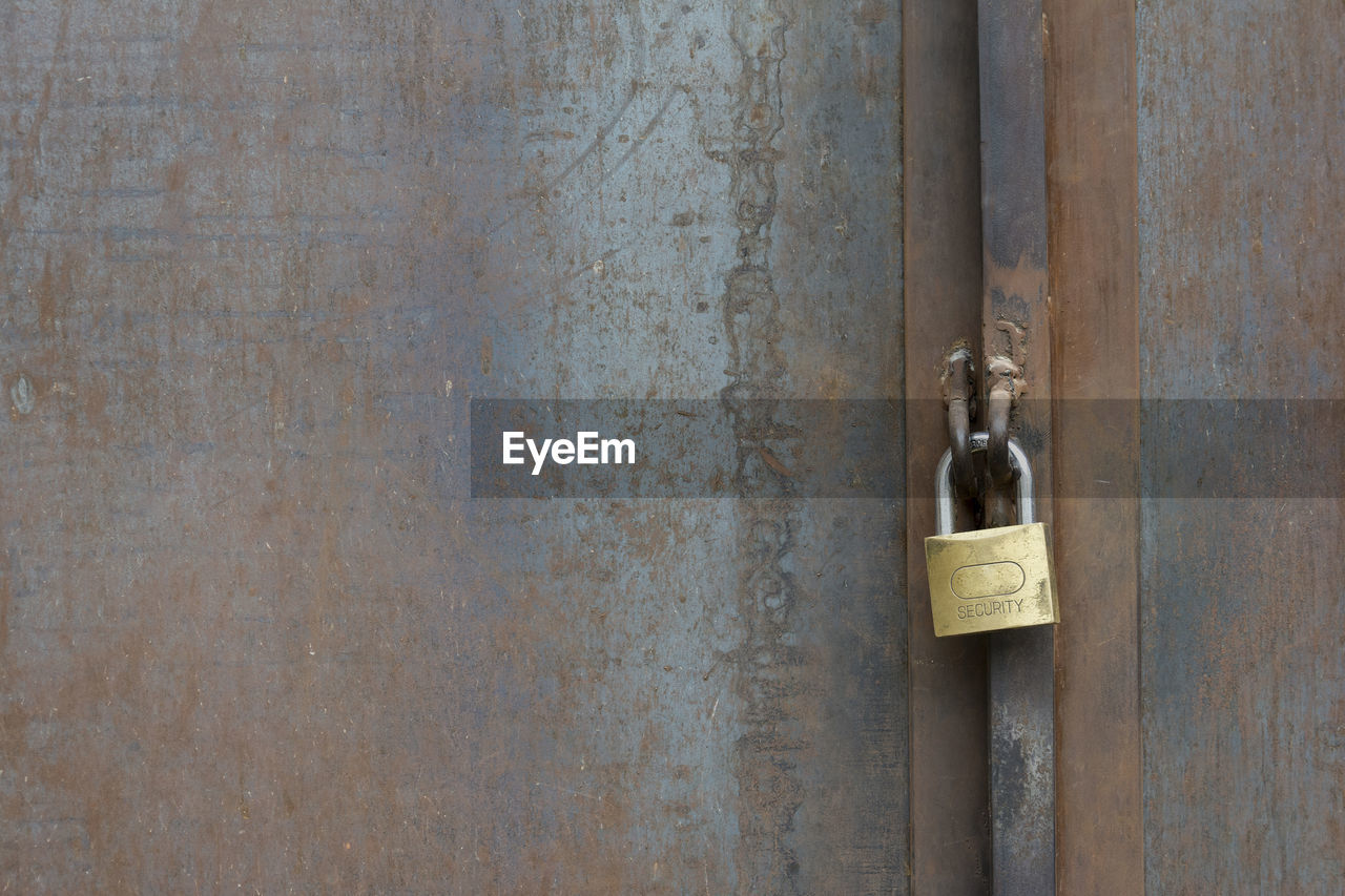 CLOSE-UP OF PADLOCK ON DOOR WITH CLOSED METAL