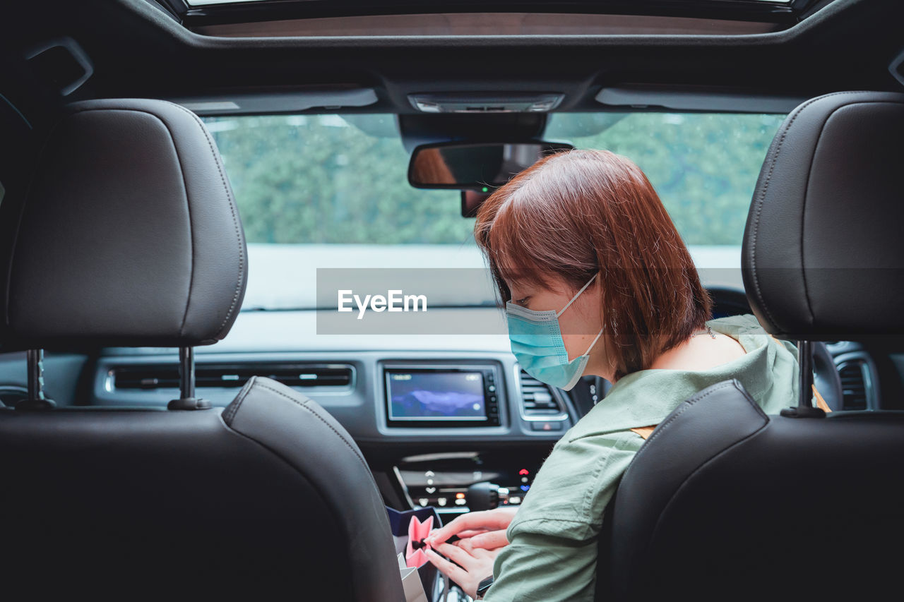 Rear view of woman in car