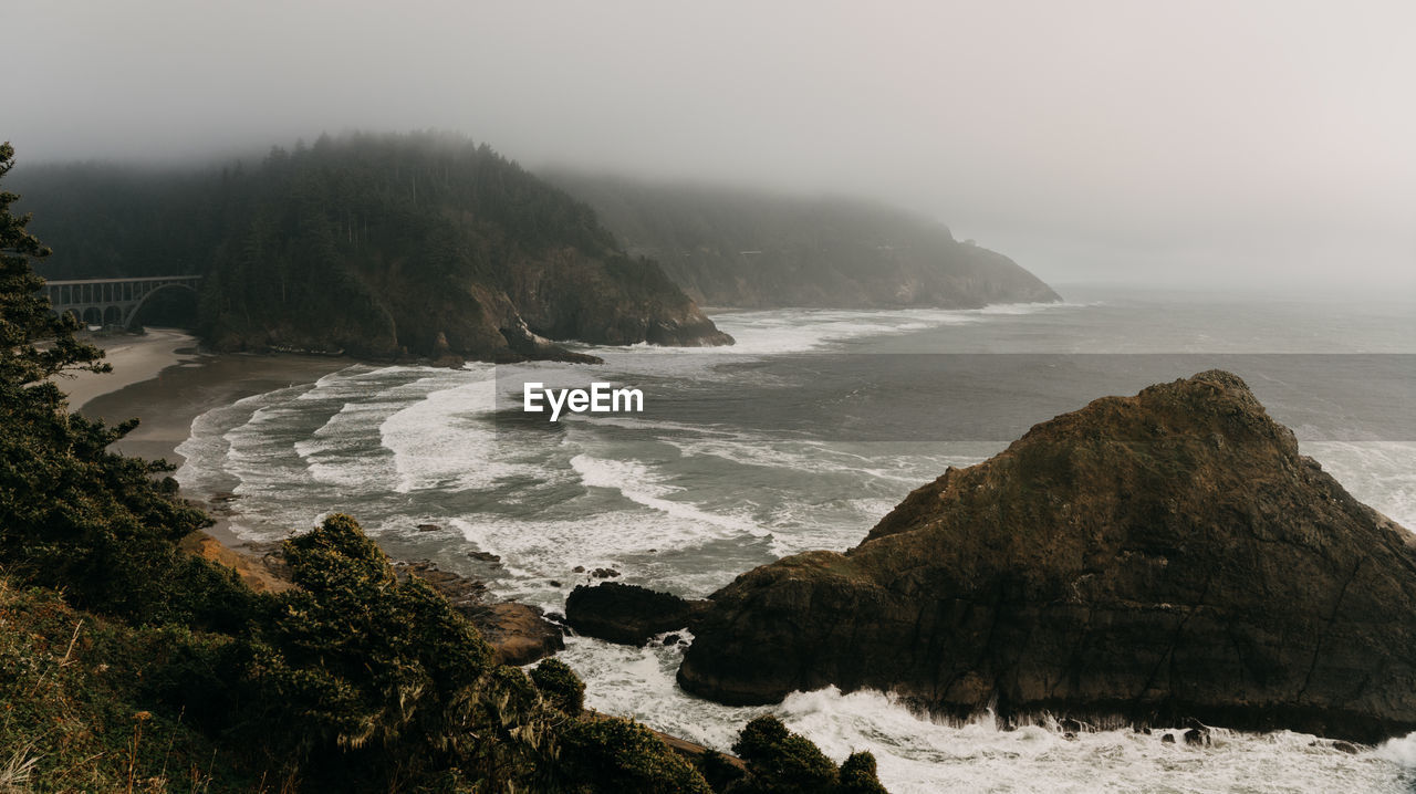 Scenic view of rocks in sea against sky