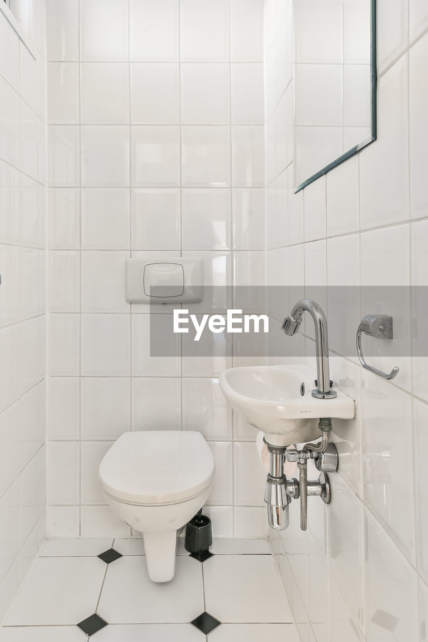 INTERIOR OF BATHROOM WITH WHITE WALL