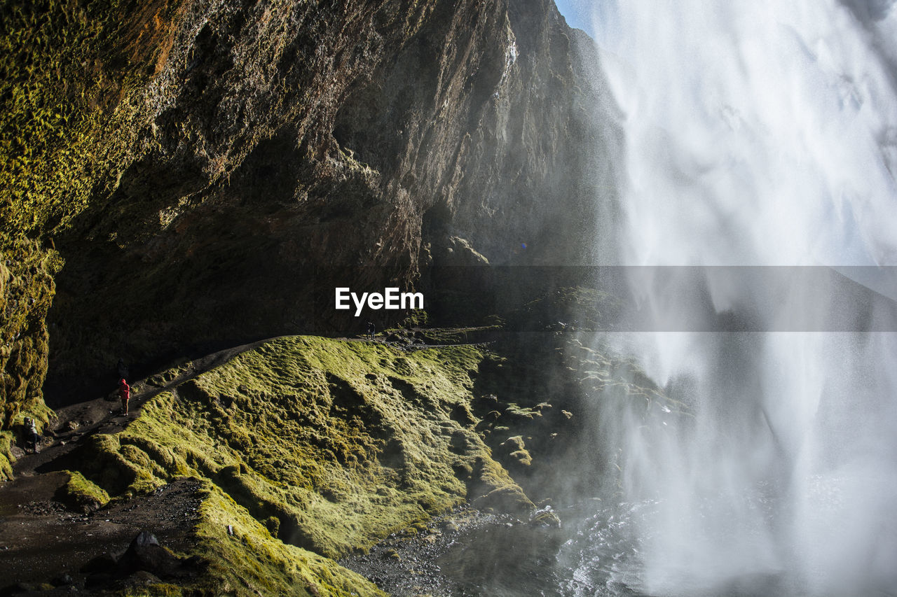 Scenic view of waterfall by rock formation