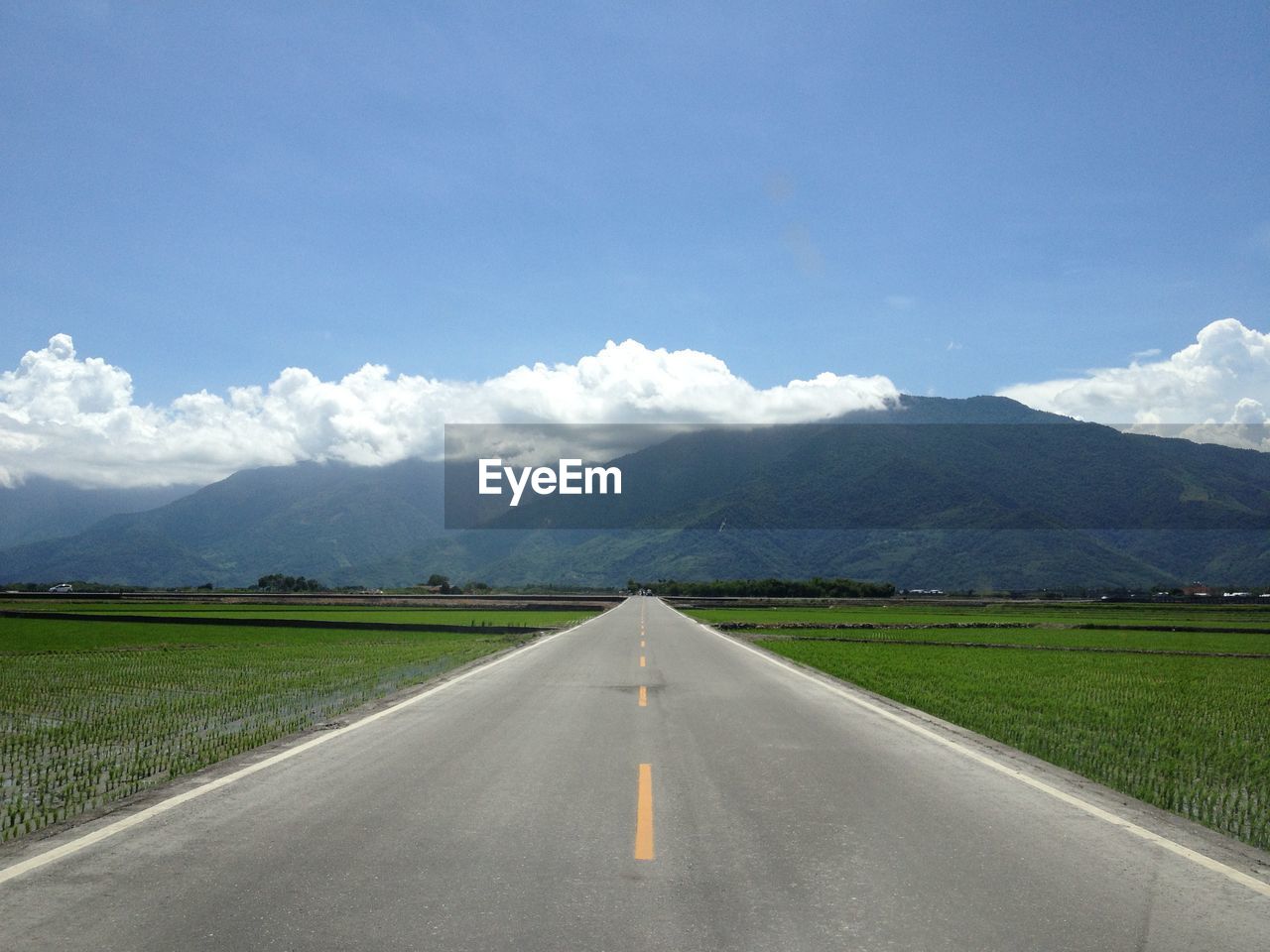 COUNTRY ROAD WITH MOUNTAINS IN BACKGROUND