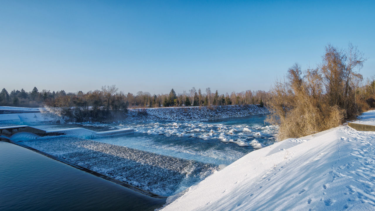 Scenic view of river against clear sky during winter