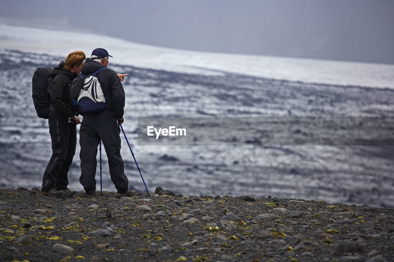 Woman pointing towards glacier on laugavegur trek