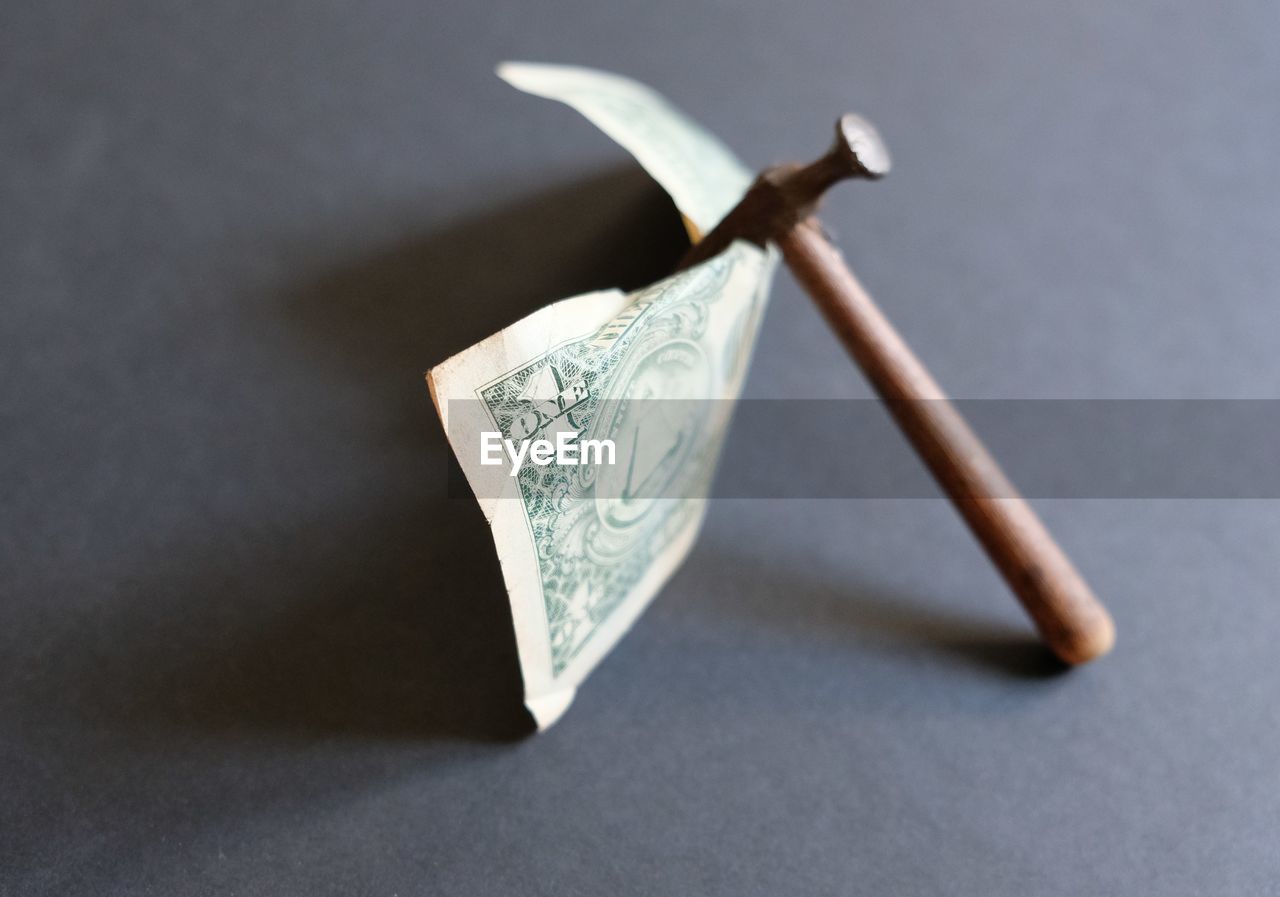 Close-up high angle view of paper currency and work tool on table