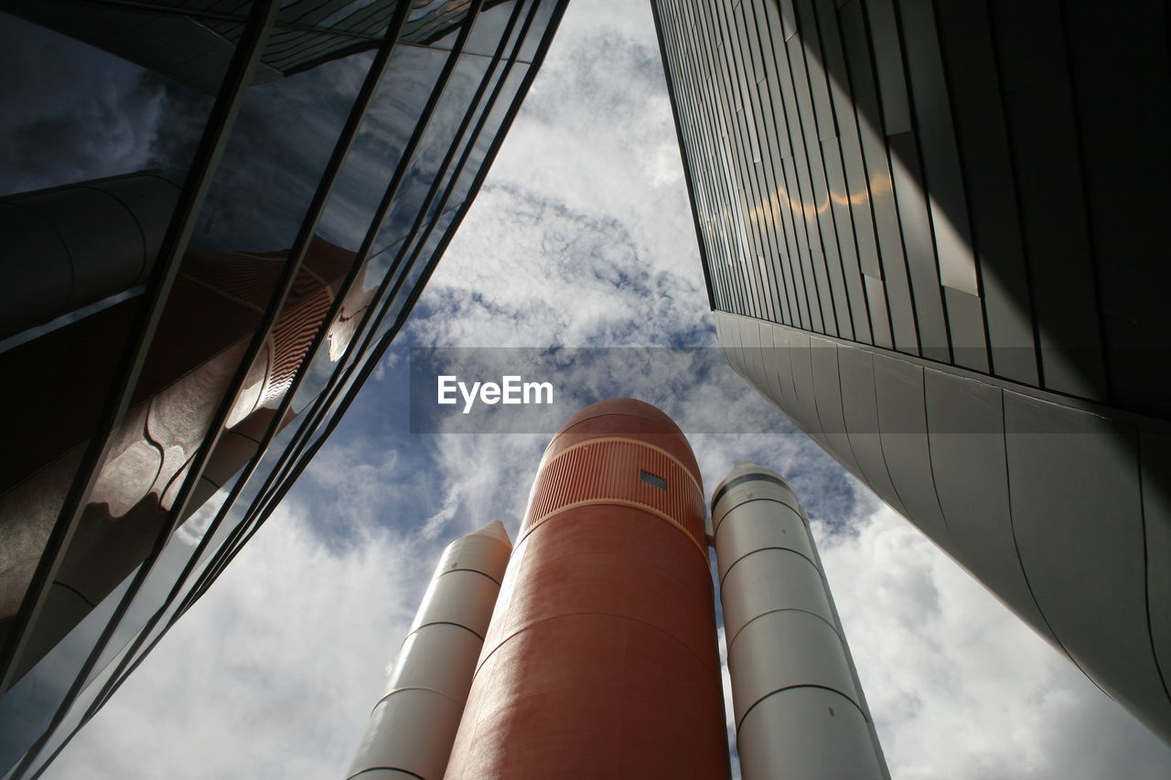 Low angle view of rocket against cloudy sky in kennedy space center