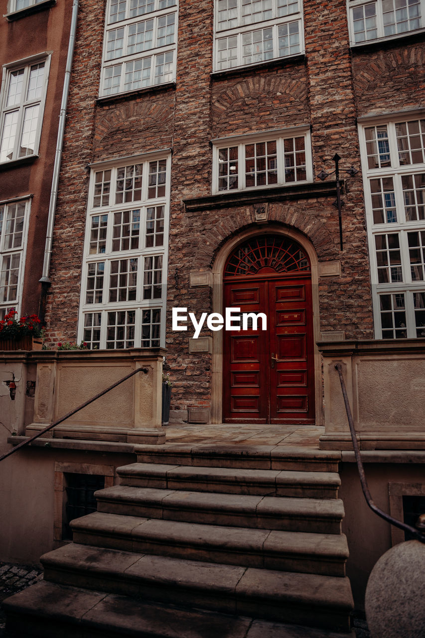 architecture, built structure, building exterior, urban area, brick, building, window, staircase, wall, house, wood, no people, city, street, low angle view, facade, day, steps and staircases, residential district, entrance, stairs, door, road, downtown, railing, arch, brickwork, outdoors, history