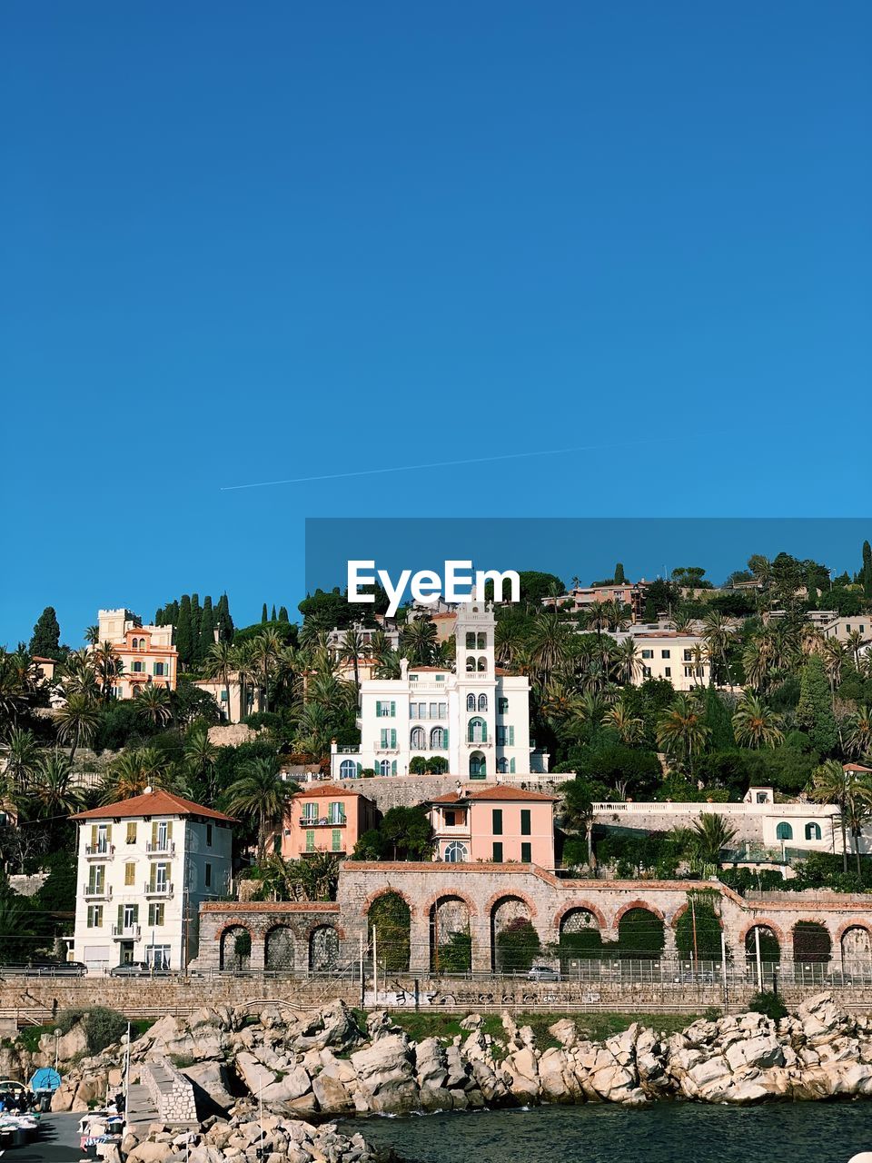 Buildings in town against clear blue sky