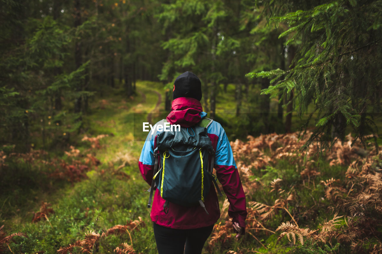 Woman walking through autumn forest