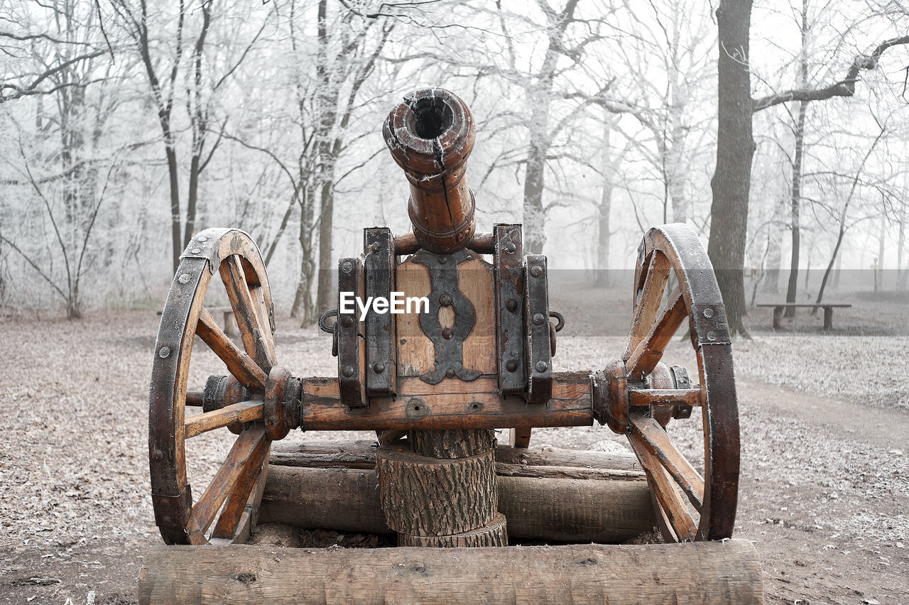 Old wooden cannon of the cossacks, on a pedestal in the winter forest