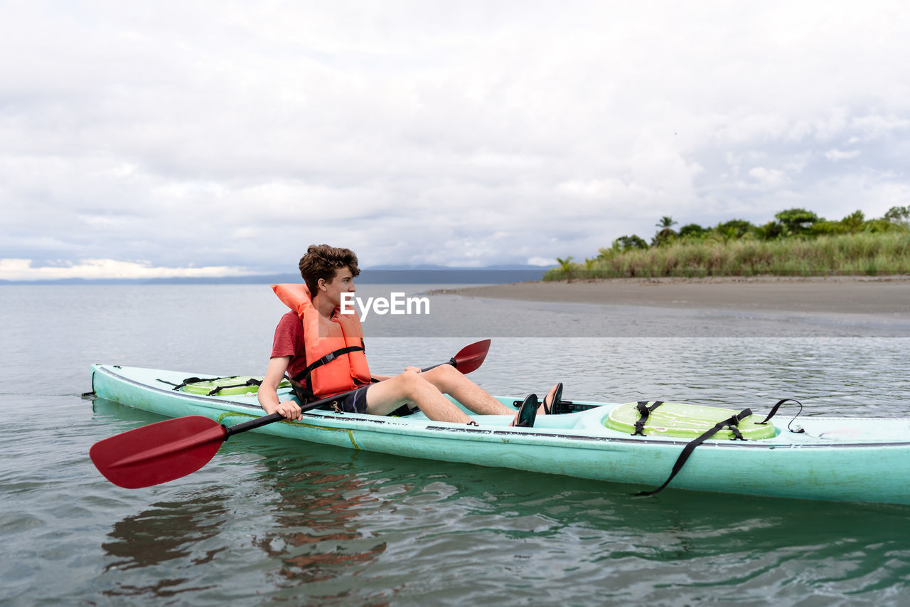 Teen relaxing in kayak in costa rica