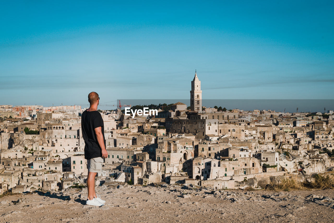 Rear view of man looking at ancient city of matera