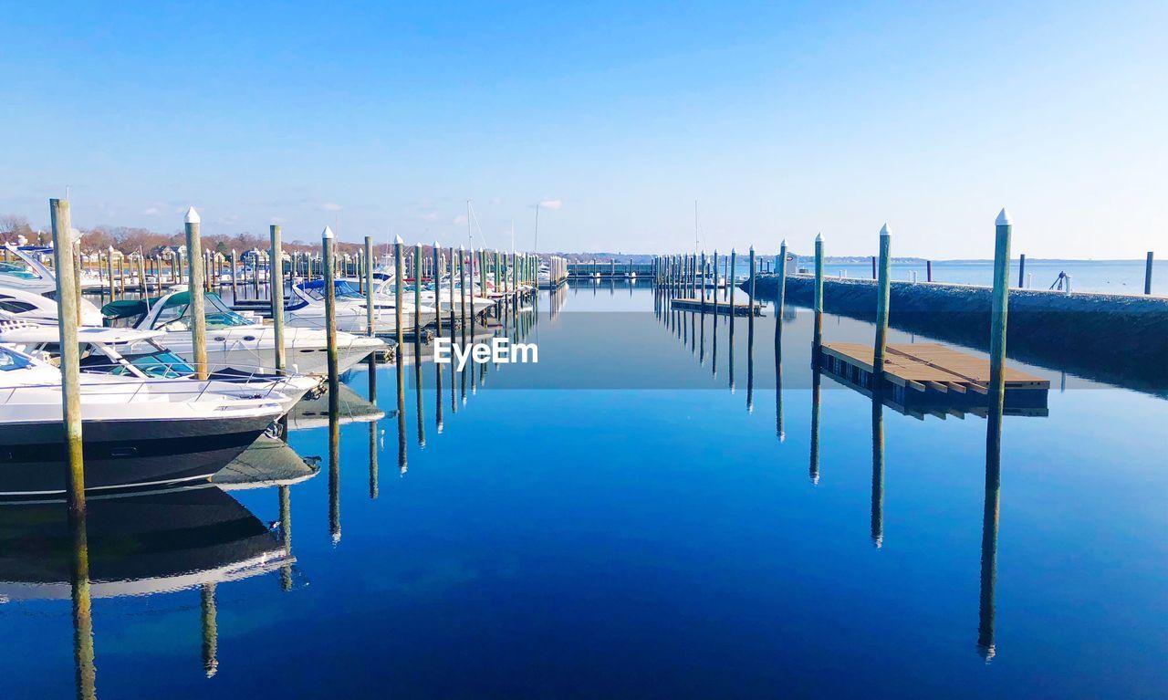 Pier over sea against clear blue sky