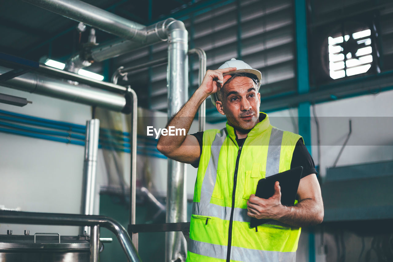 Engineer looking away at factory