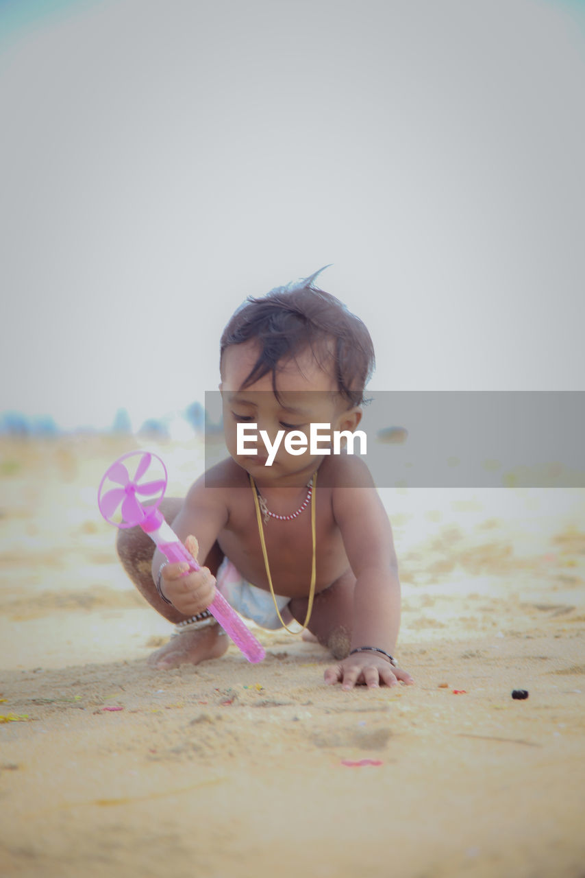 childhood, child, beach, sand, land, one person, nature, water, skin, toddler, baby, holiday, sea, innocence, human face, summer, female, fun, cute, women, copy space, trip, clothing, vacation, full length, person, emotion, sky, pink, hand, leisure activity, outdoors, happiness, day, swimwear, front view, smiling, selective focus, looking, body of water, enjoyment, brown hair, looking down, toy, photo shoot, lifestyles, spring