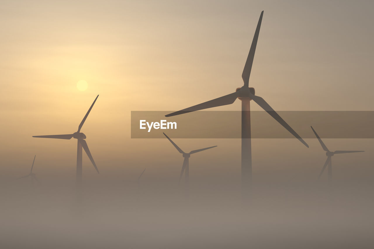 Landscape with a wind farm on a foggy morning. aerial view. the sun rises