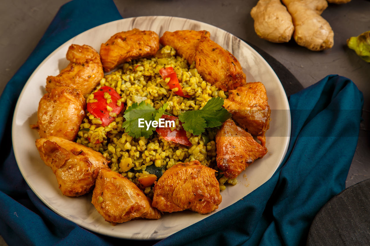 Food for suhoor in ramadan bulgur fast with beef in a plate on a blue napkin next to vegetables