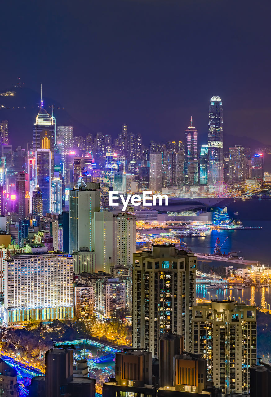 Illuminated buildings in city against sky at night