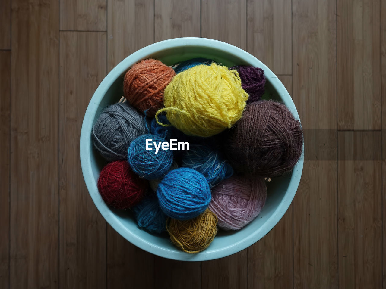 wood, multi colored, ball of wool, material, wool, craft, indoors, no people, textile, food and drink, thread, food, directly above, variation, still life, studio shot, table, high angle view, creativity, bowl, tradition, knitting needle, yellow