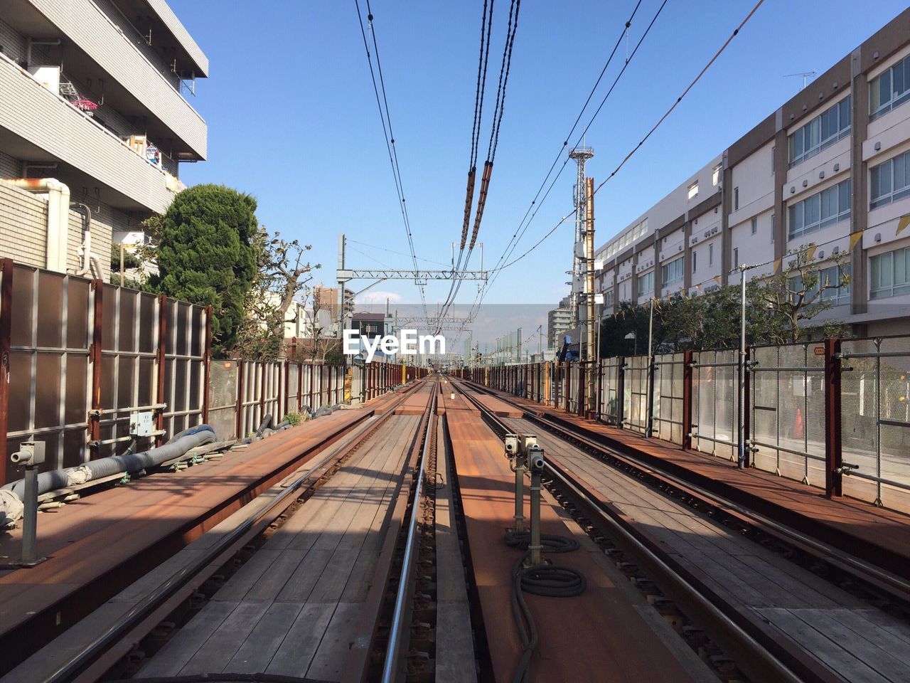 Railroad tracks in city against clear sky