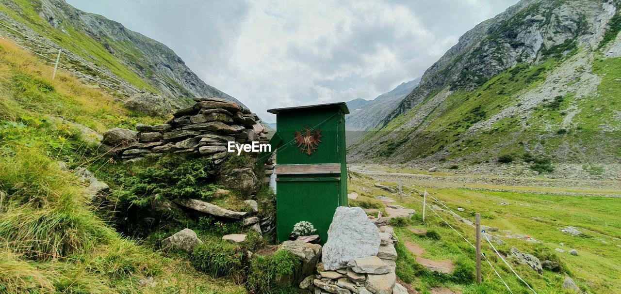 Panoramic view of green landscape against sky with bathroom toilette 