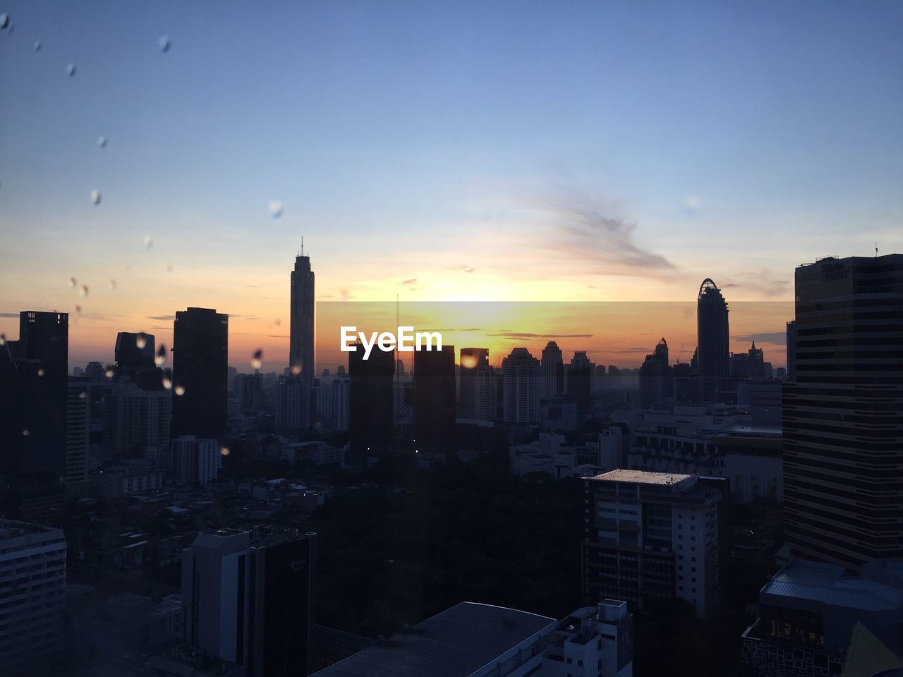 VIEW OF BUILDINGS IN CITY AT SUNSET