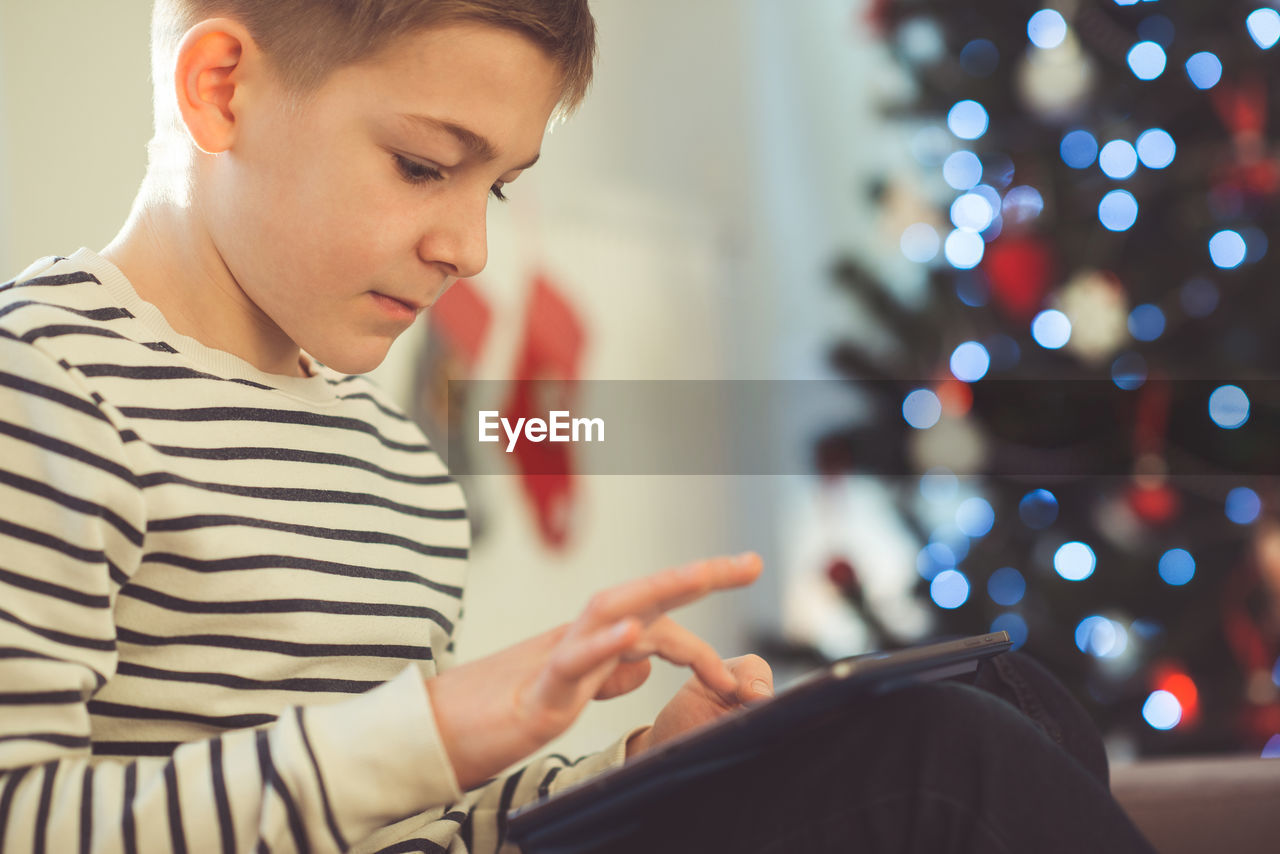 Boy using digital tablet at home during christmas