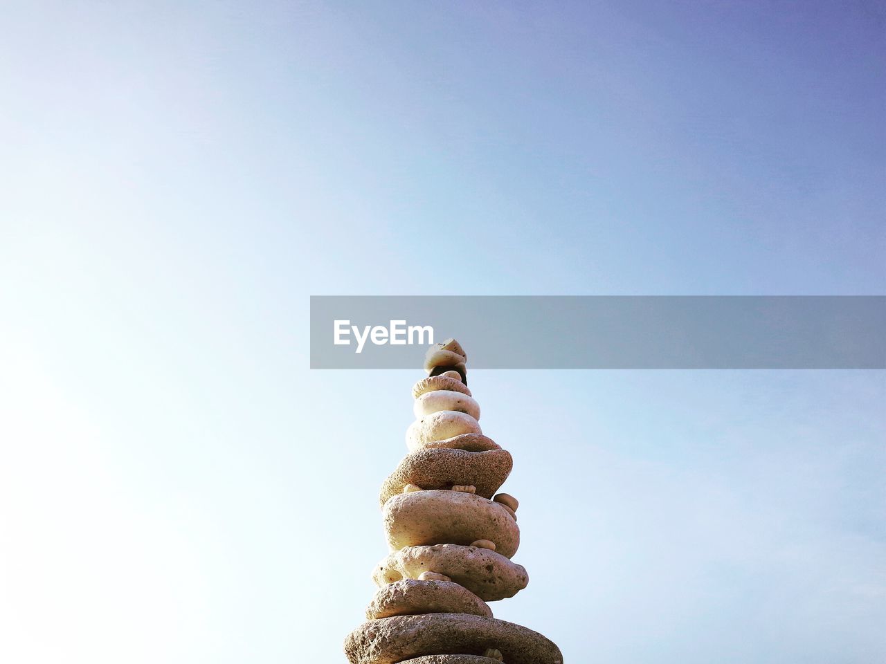 Low angle view of stones stacked against sky