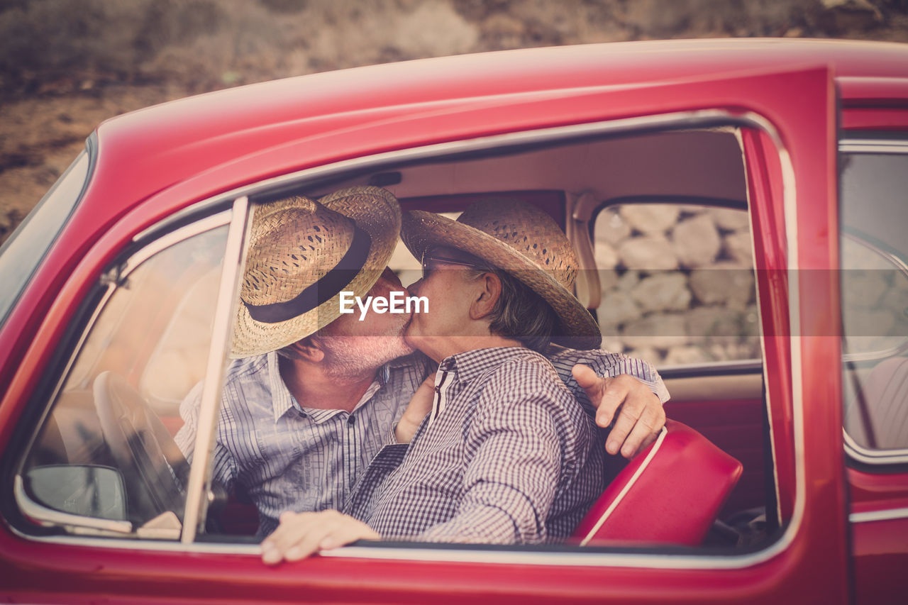 Senior couple kissing in vintage car