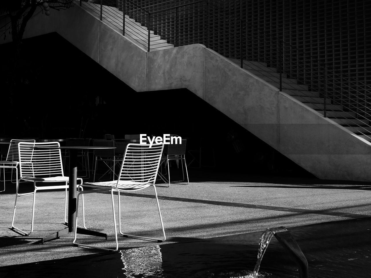 Beautiful light and shadow contrast of street furniture and staircase of a restaurant.